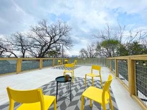 a row of yellow chairs and tables on a deck at Downtown Views, Rooftop Deck, Pets in Dallas