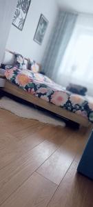Ce lit se trouve dans un dortoir doté de parquet. dans l'établissement NOVA Apartment, à Sanok