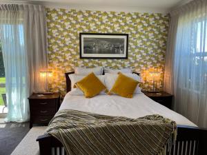 a bedroom with a large bed with yellow wallpaper at Ra-ata Farm in Rangiora