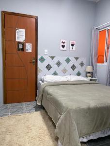 a room with a bed and a wooden door at Residencial Napolitan in Manaus