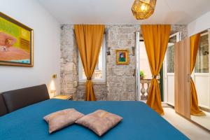 a bedroom with a blue bed with two pillows on it at IDA ARTS APARTMENTS in Zadar