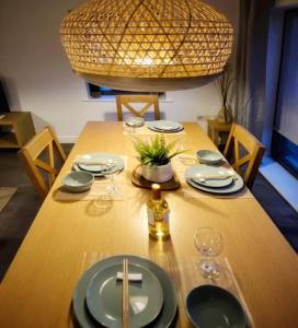 een houten tafel met borden en wijnglazen erop bij Japanese Style MUJI Two-Bedroom Apt in Swansea