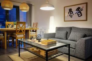 a living room with a couch and a table at Japanese Style MUJI Two-Bedroom Apt in Swansea