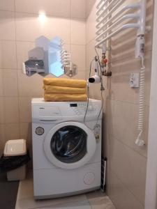 a washing machine with towels on top of it in a bathroom at Apartament w Krakowie in Krakow