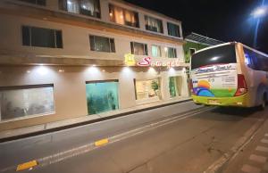 un autobús estacionado frente a un edificio por la noche en Hotel Senegal, en Pasto