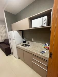 a small kitchen with a sink and a refrigerator at Lagoa EcoTowers Resort Hotel in Caldas Novas