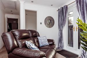 a brown leather recliner in a living room at Willow Chalet near Cartmel & Lake Windermere in Flookburgh