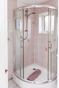 FlookburghにあるWillow Chalet near Cartmel & Lake Windermereのバスルーム(ガラス張りのシャワー付)が備わります。