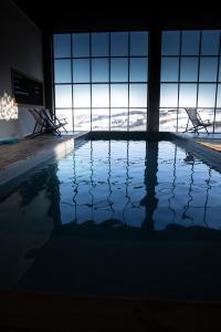 a swimming pool with a view of the snow covered mountains at Un petit bout du monde in Saint-Georges-en-Couzan
