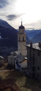 a building with a tower with a clock on it at Ca' del bau in Chiesa in Valmalenco