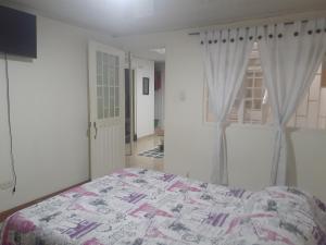 1 dormitorio con 1 cama en una habitación con ventana en San Francisco en Kennedy, en Bogotá