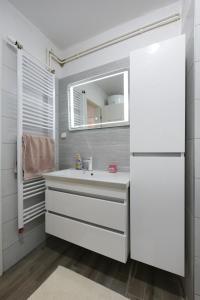 La salle de bains est pourvue d'un lavabo et d'un miroir. dans l'établissement Apartment Teodora, à Zadar