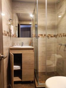 a bathroom with a sink and a glass shower at Hotel Montefiore in Bogotá