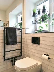 a bathroom with a toilet and plants on the wall at Glos Homes Presents - Old Coach House a Quiet Place near Town Centre in Cheltenham