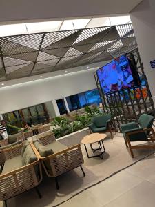 ein Wohnzimmer mit Stühlen und einem großen Bildschirm in der Unterkunft Lagoa EcoTowers Resort Hotel in Caldas Novas