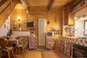 una cocina con paredes de madera y una mesa en una habitación en CASA VACANZA "AI PIEDI DEL BOSCO", en Malborghetto Valbruna