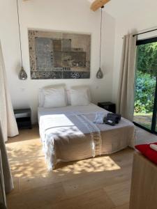 una camera da letto con un letto e un dipinto sul muro di Villa Griseor a Porto Vecchio