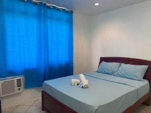 a bedroom with a bed with two stuffed animals on it at ROMY'S PLACE - ENTIRE 3RD FLOOR APARTMENT in Vigan