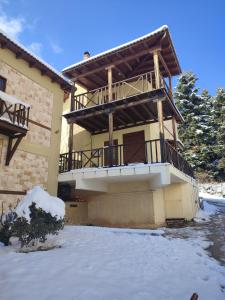 un edificio con balcone con neve al suolo di Evergreen Suites a Synikia Mesi Trikalon
