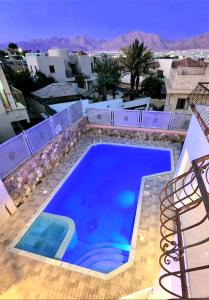 a large blue swimming pool on top of a building at VILLA SHUNIT- וילה שונית by barak royal suites in Eilat