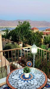 d'une terrasse avec une table et des chaises sur un balcon. dans l'établissement VILLA SHUNIT- וילה שונית by barak royal suites, à Eilat