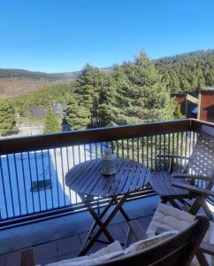 d'une terrasse avec une table et des chaises sur un balcon. dans l'établissement La Molina - acogedor apartamento cerca de las pistas de esquí, à La Molina