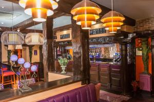 a bar with orange and purple chairs and lights at Duke Of Normandie in St. Peter Port