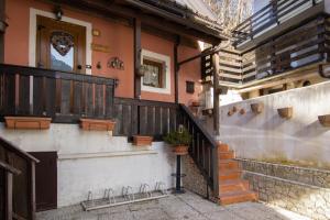 Casa con escaleras y balcón con puerta en CASA VACANZA "AI PIEDI DEL BOSCO", en Malborghetto Valbruna