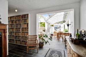 uma sala com uma biblioteca com estantes e uma mesa em Hotel Aahøj em Sæby