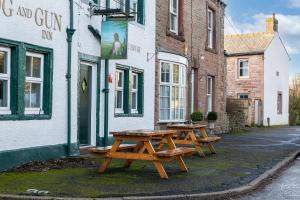 three picnic tables sitting outside of a building at Brow Top Cottage, Penrith, Lake District in Skelton