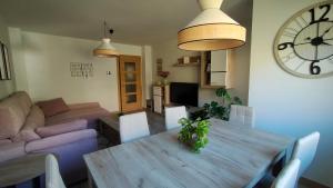 a living room with a wooden table and a clock at Peñas de Arnedillo in Arnedillo