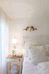 洛杉磯的住宿－Elegant White Cottage, Venice Beach, California，一间卧室配有一张床和一张带台灯的桌子