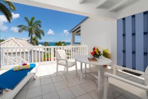 a balcony with a table and chairs and the ocean at La Vista Resort in Simpson Bay