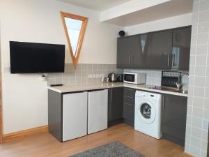 a kitchen with a washer and dryer in it at Hastings Pad in Hastings