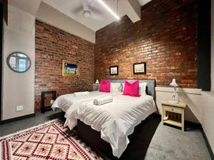 a bedroom with a large bed with a brick wall at No load-shedding Spacious Apartment in Cape Town +23 photos