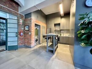 a kitchen with a table and a brick wall at No load-shedding Spacious Apartment in Cape Town