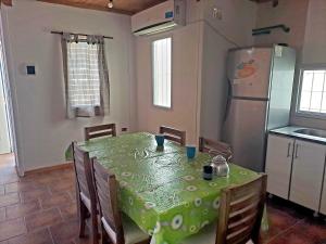 uma cozinha com uma mesa com cadeiras e um frigorífico em NEUQUEN alojamiento em Neuquén