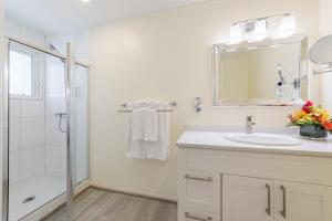 a white bathroom with a sink and a shower at La Vista Resort in Simpson Bay