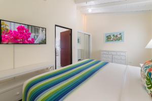 a bedroom with a bed and a tv on the wall at La Vista Resort in Simpson Bay
