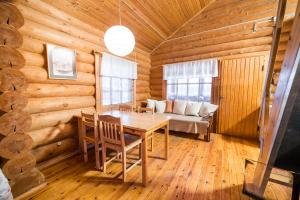 a dining room with a table in a log cabin at Peurasuvanto Mökit & Camping in Peurasuvanto