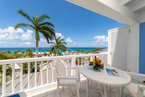 a balcony with a table and chairs and the ocean at La Vista Resort in Simpson Bay