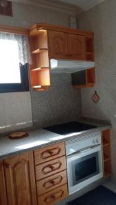 kuchnia z drewnianymi szafkami i kuchenką z piekarnikiem w obiekcie Casa Victoria, Playa Chica w Puerto de la Cruz +3 zdjęcia