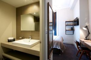 a bathroom with a sink and a bed at Kew Gardens Hotel in Kew