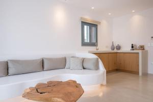 a white living room with a couch and a table at Aba Ηospitalité, The Deluxe Suite, Naousa in Naousa