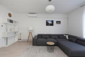 - un salon avec un canapé bleu et une table dans l'établissement Apartment Teodora, à Zadar
