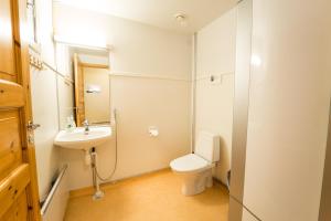 a small bathroom with a toilet and a sink at Peurasuvanto Mökit & Camping in Peurasuvanto +80 photos