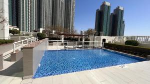 阿布達比的住宿－Prestigeo Guest House Abu Dhabi，一座位于城市的游泳池,有高大的建筑
