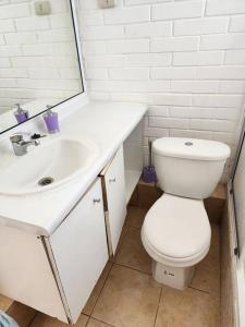 a bathroom with a white sink and a toilet at Casa a pocos minutos de playa La Herradura in Coquimbo