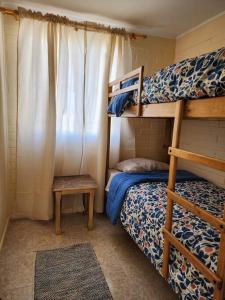1 Schlafzimmer mit 2 Etagenbetten und einem Tisch in der Unterkunft Casa a pocos minutos de playa La Herradura in Coquimbo
