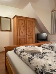 a bedroom with a bed with a dresser and a tv at Hotel und Restaurant Grüner Hahn in Elsenfeld
